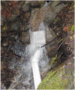 An in-stream screen keeps debris and silt out of the penstock at the small-stream intake for a microhydro system in Washington.